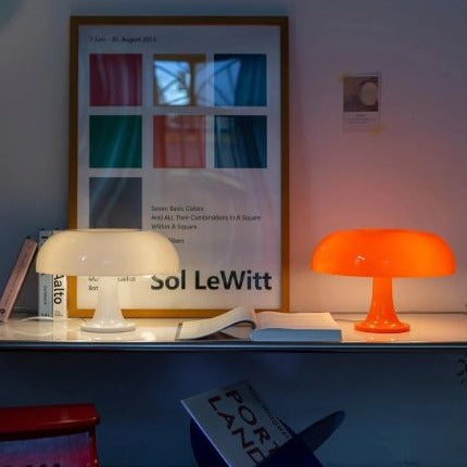 White and orange Space Age mushroom desk lamps styled together on a minimalist white shelf
