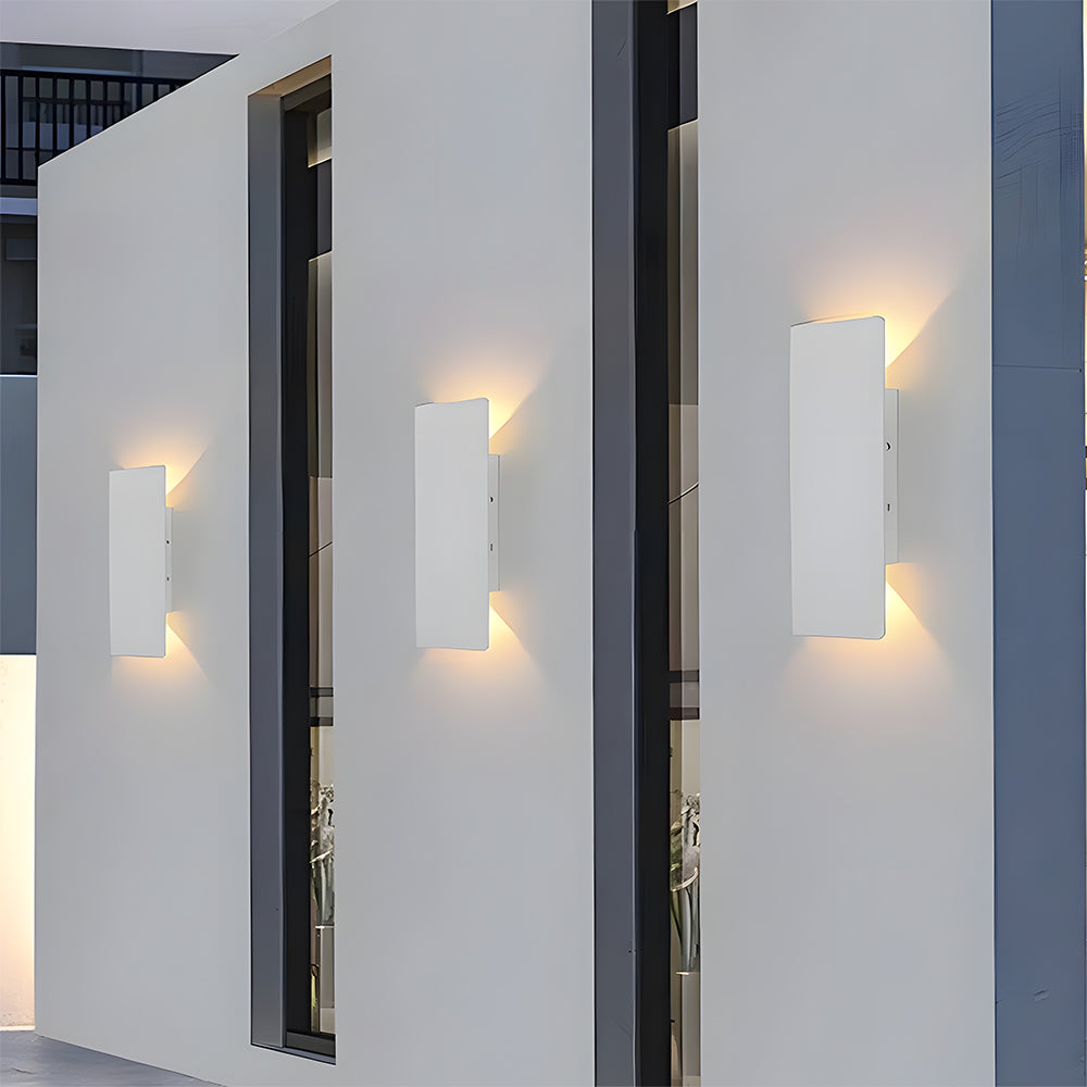 White architectural outdoor pillar lights installed on the columns of a modern home