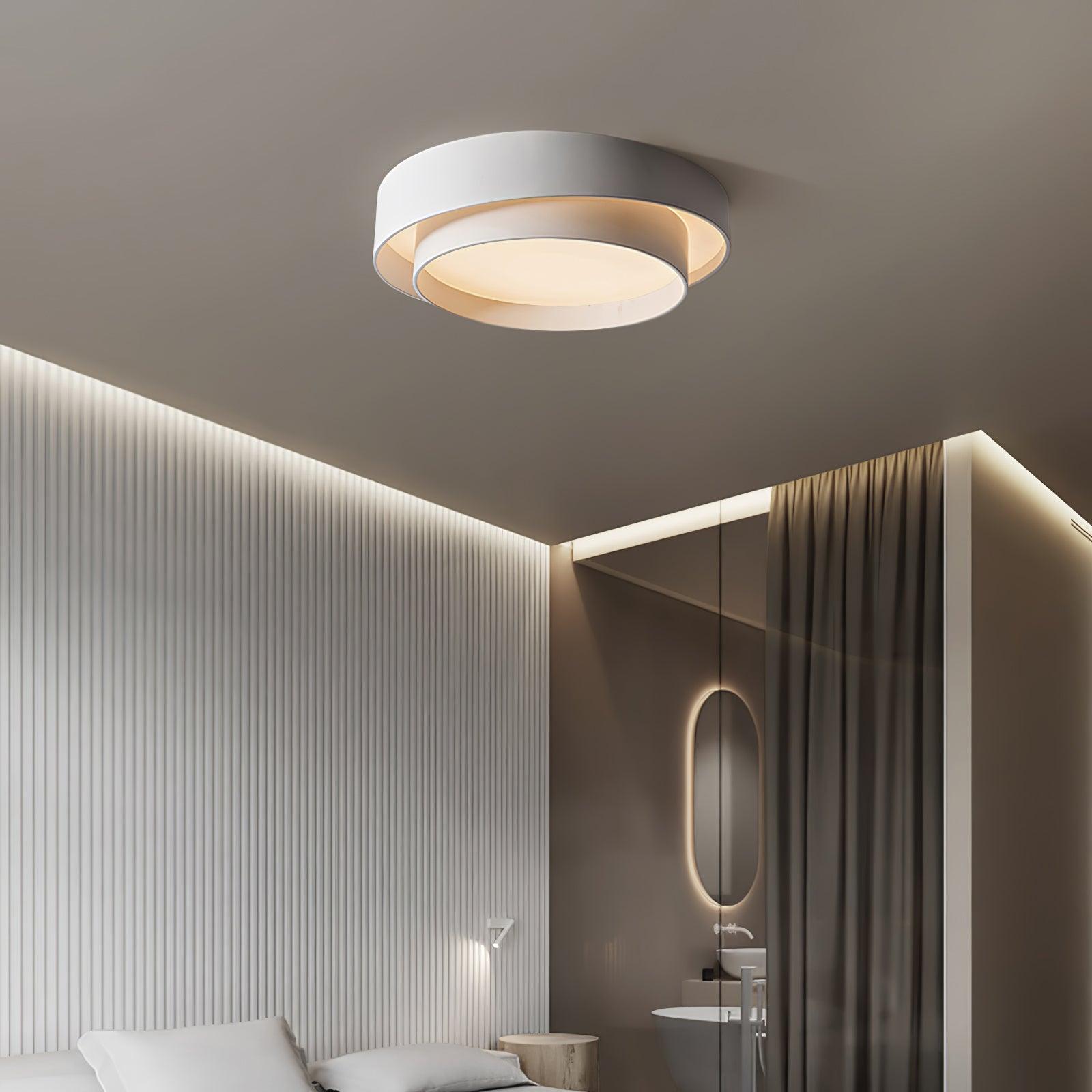White double-ring LED flush mount light installed in a bedroom featuring modern slatted wall panelling