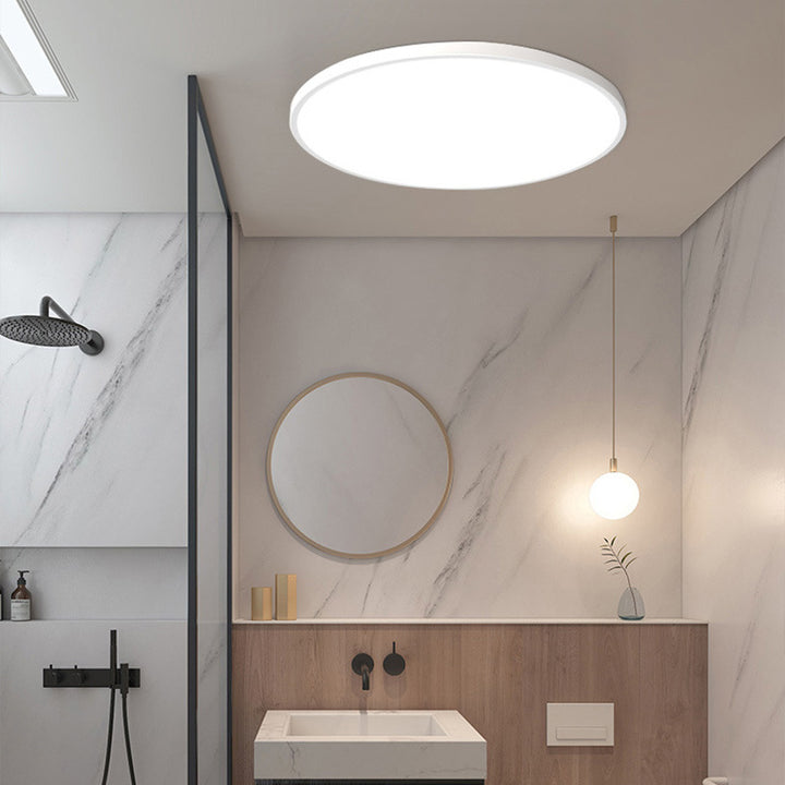 Ultra-thin white flat panel LED ceiling light installed in a sleek, modern washroom interior