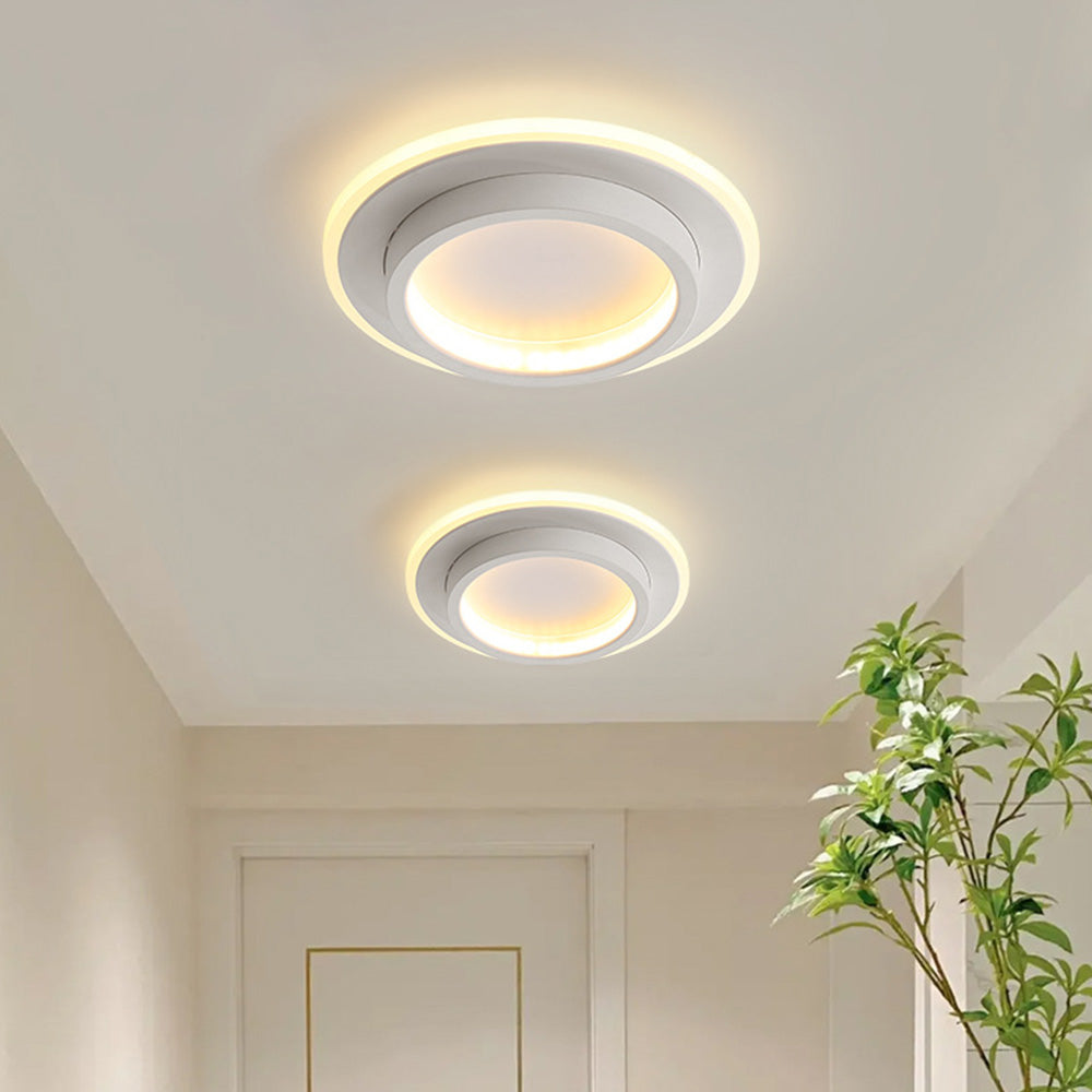Two modern white geometric LED flush mount ceiling lights illuminating a bright corridor