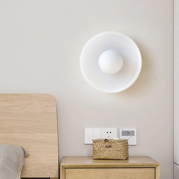 White glass wall sconce acting as an elegant bedside reading light