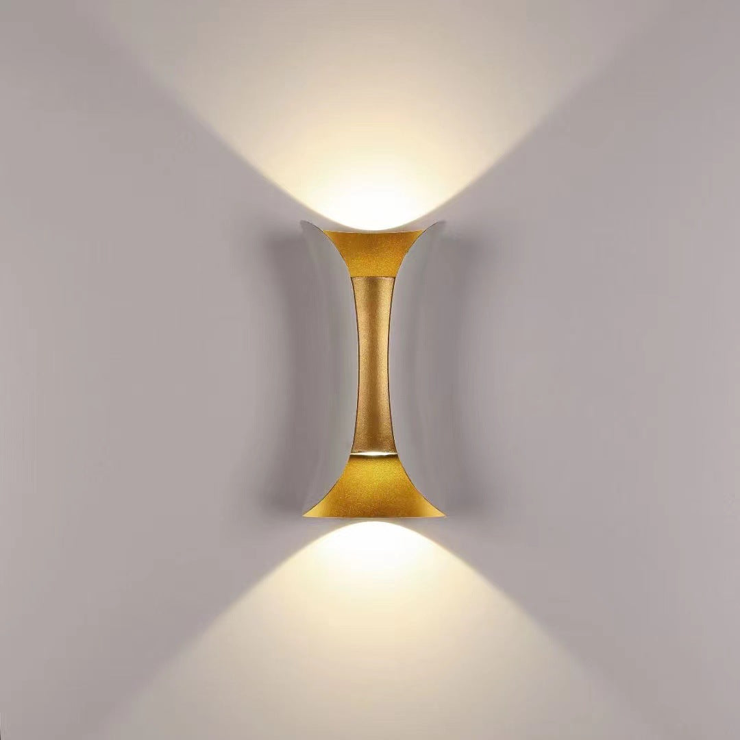 Illuminated white and gold LED up and down sconce against a neutral, warm background