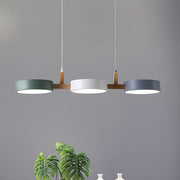 Modern white, grey, and green 3-light Nordic linear pendant suspended over a sleek dining table