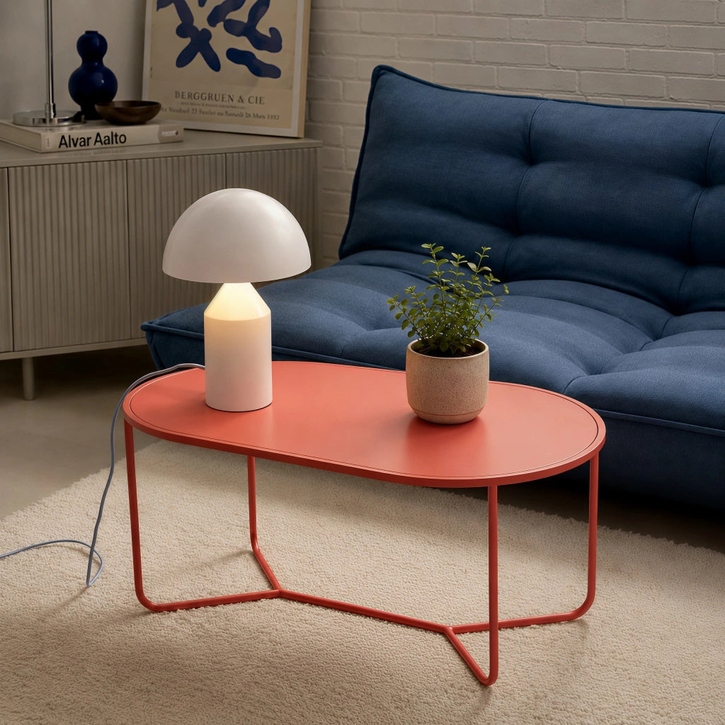 White mid-century mushroom desk light styled on a modern red coffee table in a living room