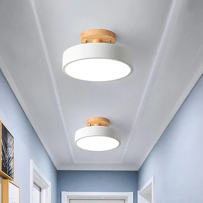 Two crisp white Nordic macaron ceiling lights contrasting beautifully in a light blue hallway