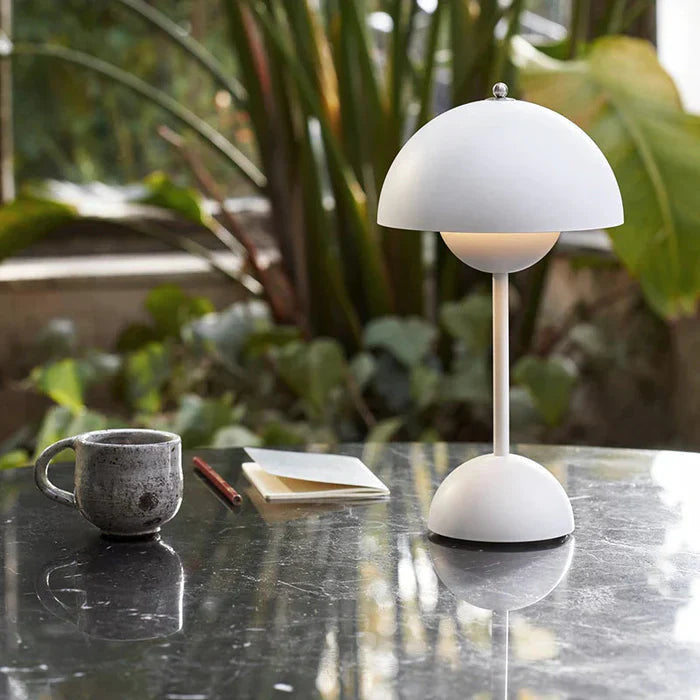 White portable cordless mushroom lamp illuminating an outdoor patio table with a coffee mug
