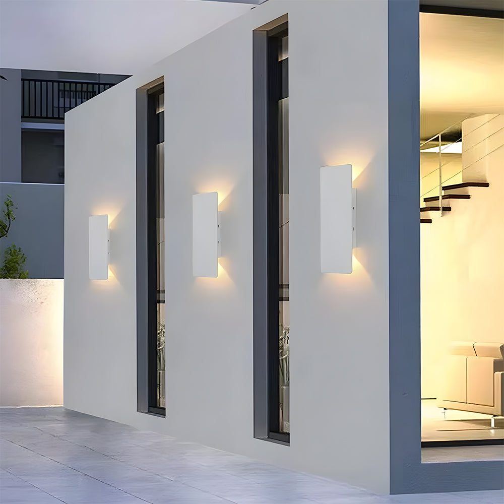 Row of white slim outdoor wall lights illuminating a modern exterior walkway