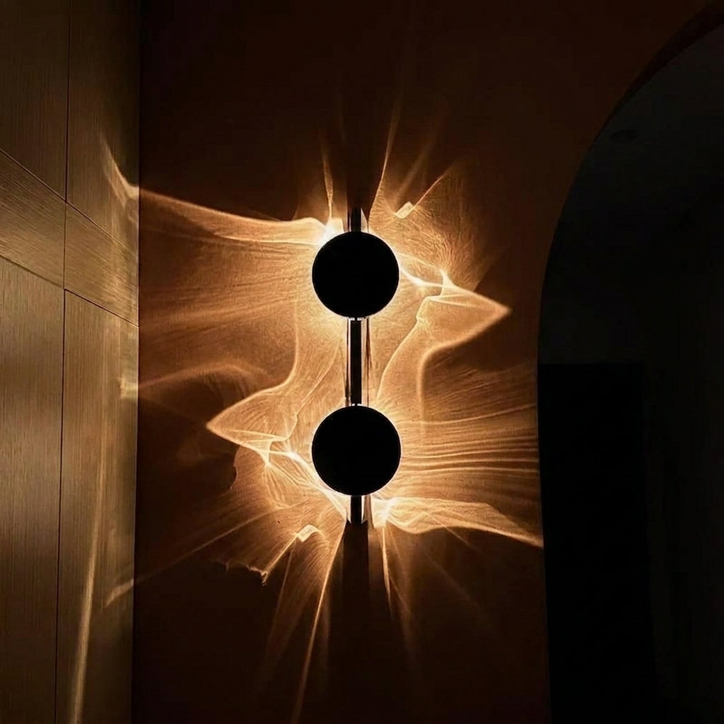 Close-up of the Wobzi wall sconce's black disc head and slim metal back plate
