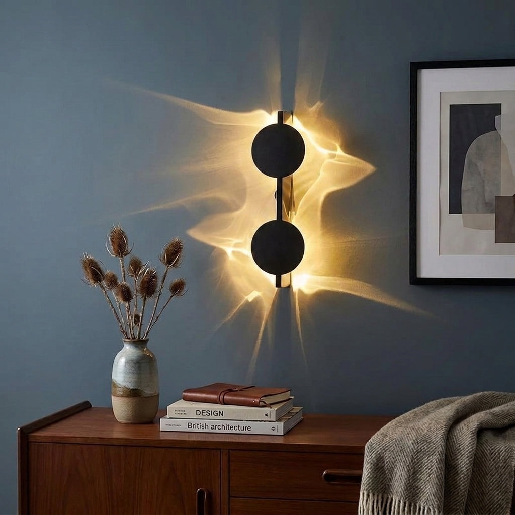 Wobzi wall sconce above a wooden dresser styled with a ceramic vase and dried flowers