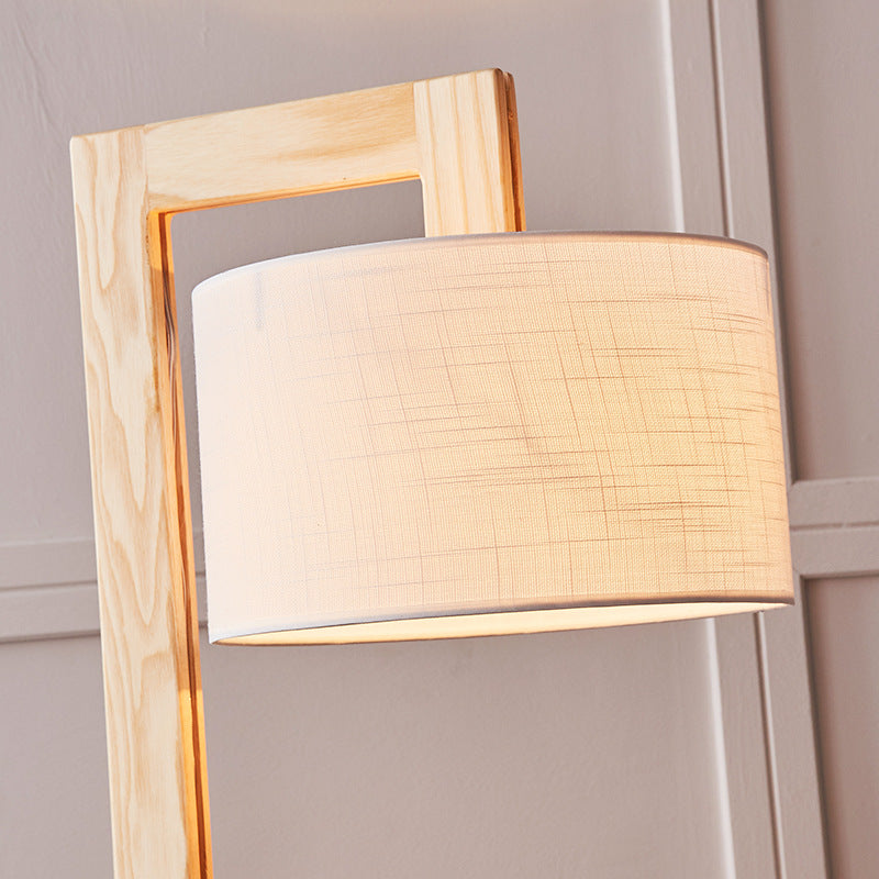 Close-up detail of the solid light wood right-angle joint and textured beige fabric lampshade