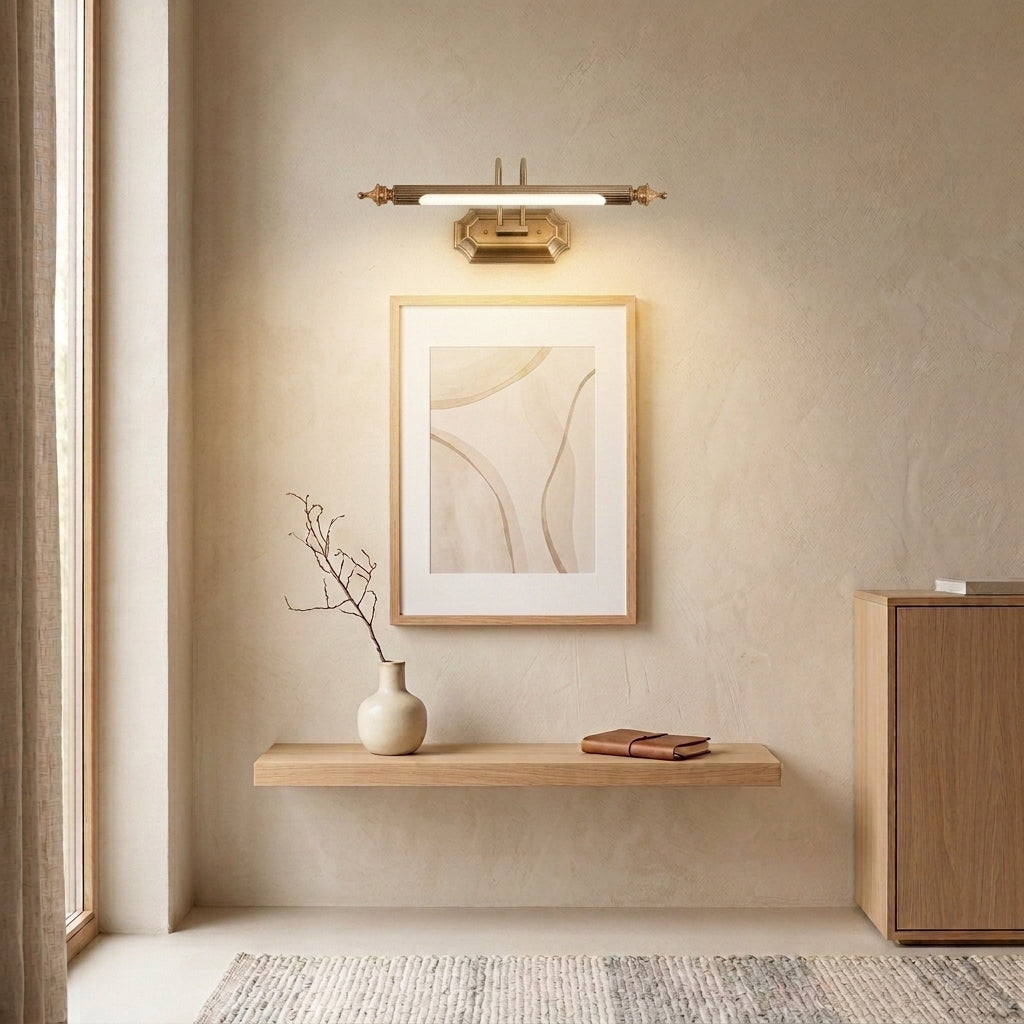 Wuxqa bronze wall light mounted above a console table with a framed picture and vase