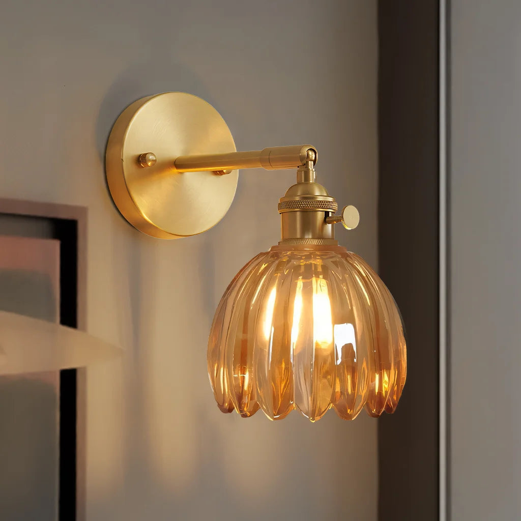 Close-up of the illuminated amber fluted xetyl glass sconce showcasing its stunning floral light and shadow effect