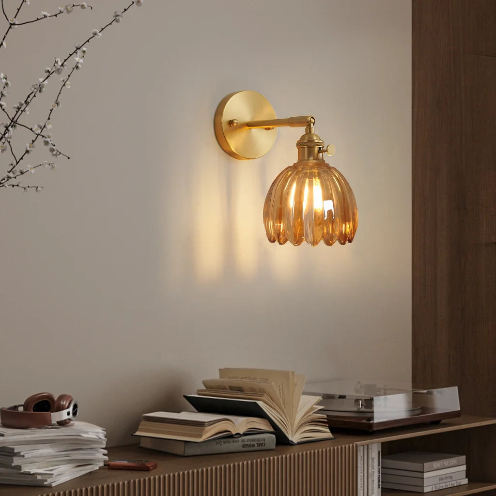 Amber xetyl lotus glass wall sconce providing warm ambient lighting above a wooden sideboard