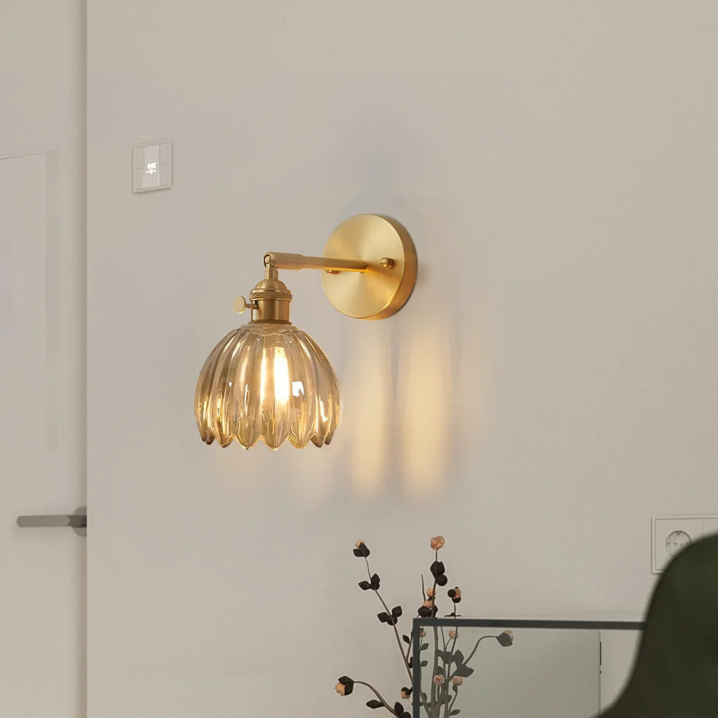 Amber xetyl vintage glass sconce glowing warmly and casting scalloped light patterns on the wall