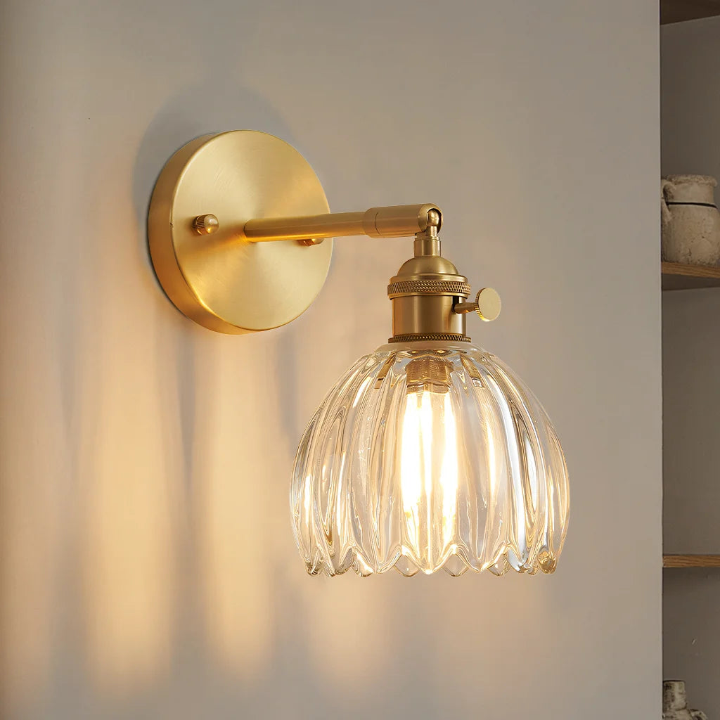 Clear fluted glass xetyl wall sconce casting a beautiful, romantic light reflection on a plain wall