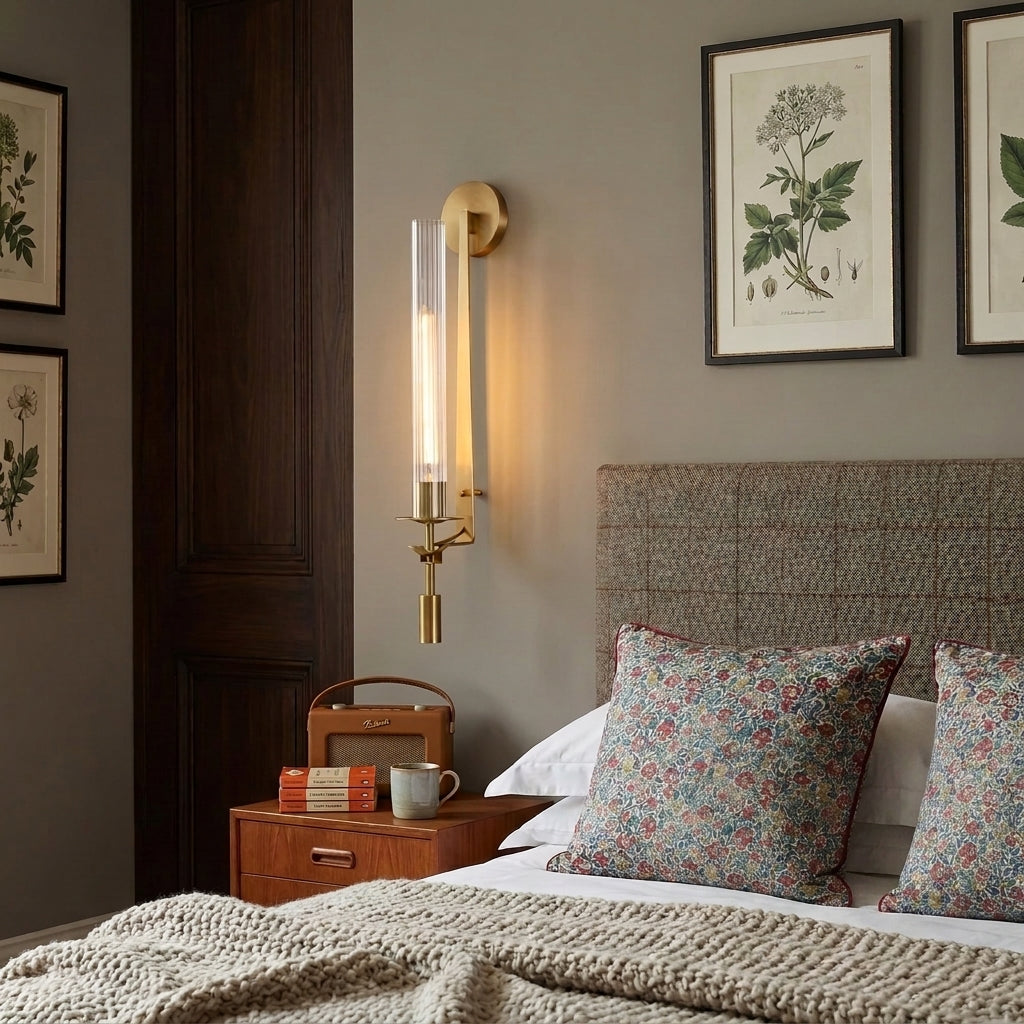 Xilpo wall sconce beside a tweed upholstered headboard with framed botanical prints