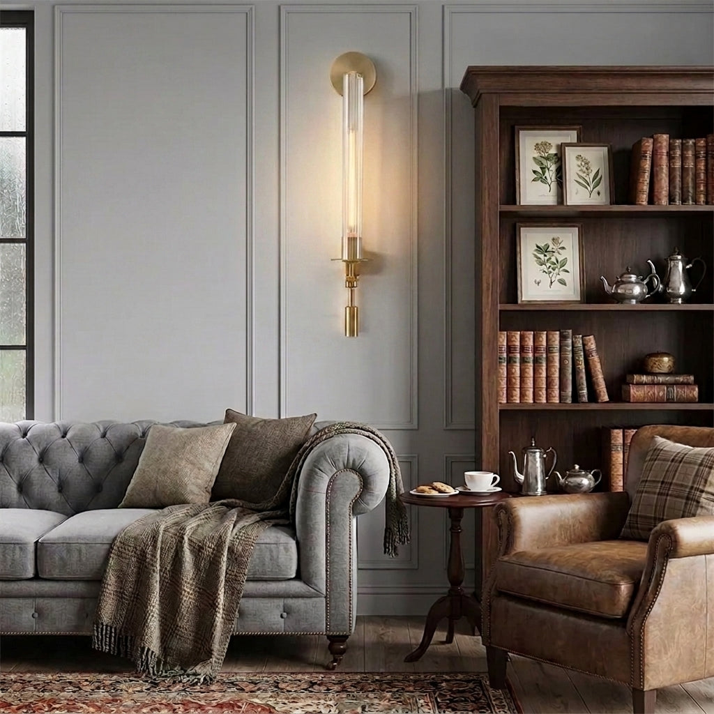 Xilpo wall sconce beside a dark armchair and a wooden bookcase styled with books and framed prints
