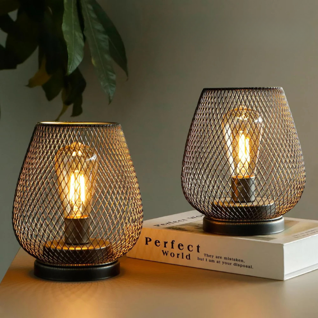Pair of xolu portable metal mesh battery table lamps providing a warm, vintage glow on a modern living room desk
