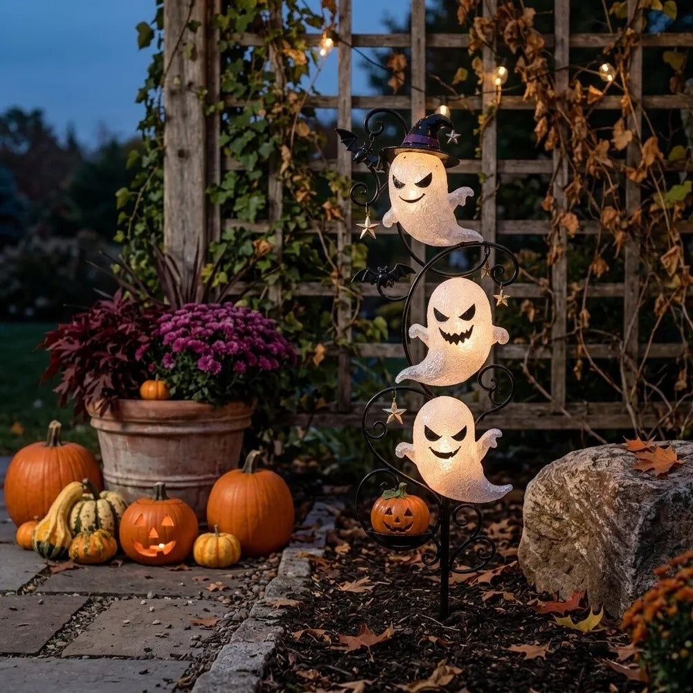 Yardmarker LED ghost garden stake glowing on a patio beside pumpkins, gourds and a garden trellis