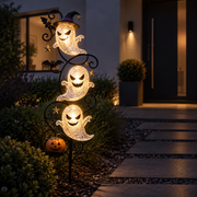 Yardmarker LED glowing ghost garden stake lit up along a front walkway at night