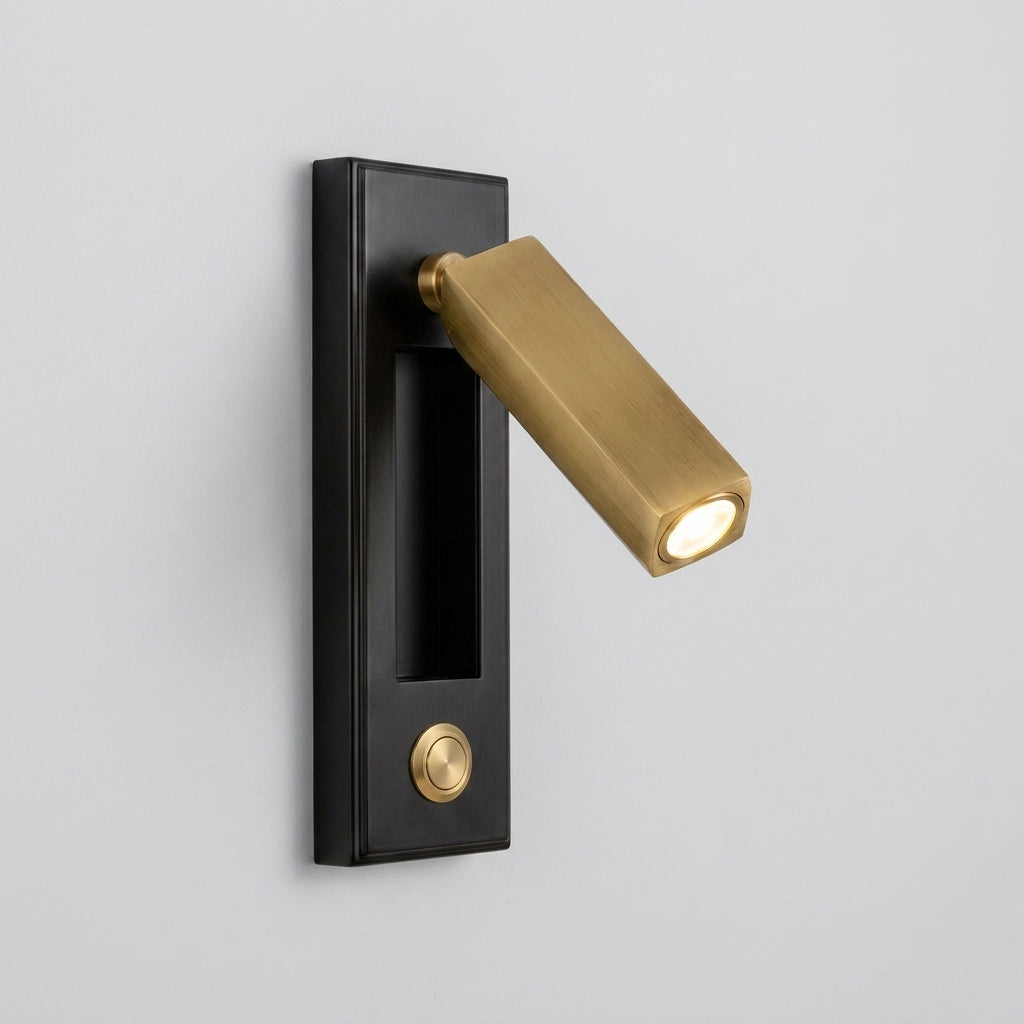 Zexto wall sconce in black and gold finish showing the button switch, alternate angle on a grey background