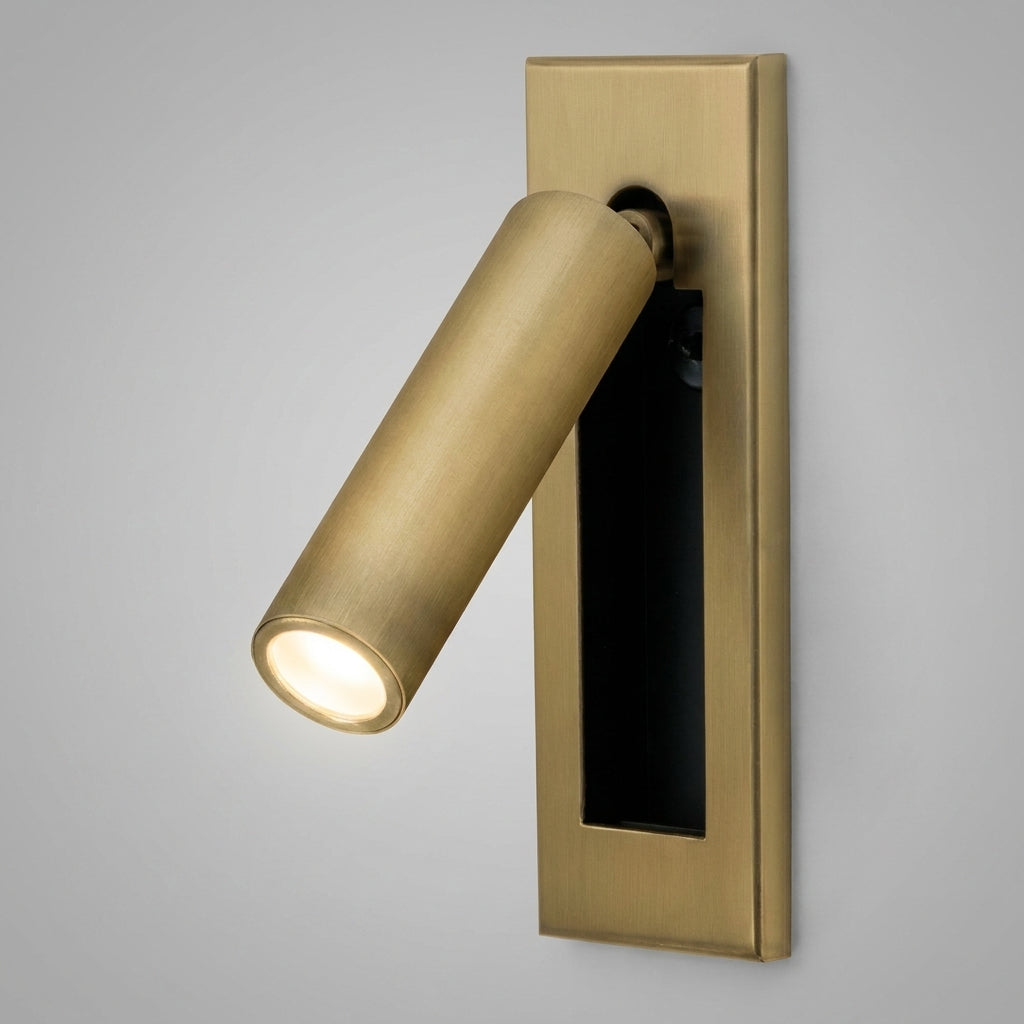 Zexto wall sconce in gold finish, illuminated, on a grey studio background