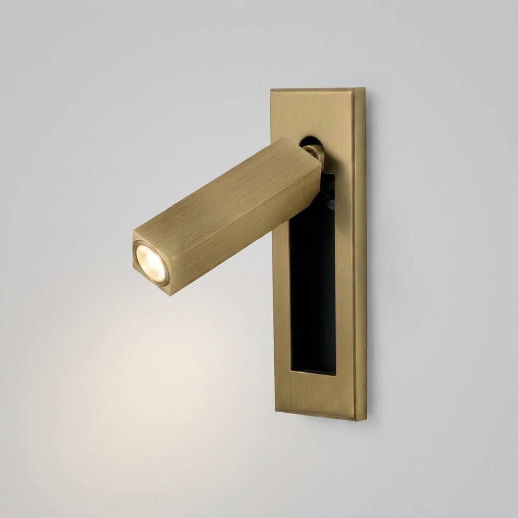 Zexto wall sconce in gold finish with hidden switch, on a grey studio background