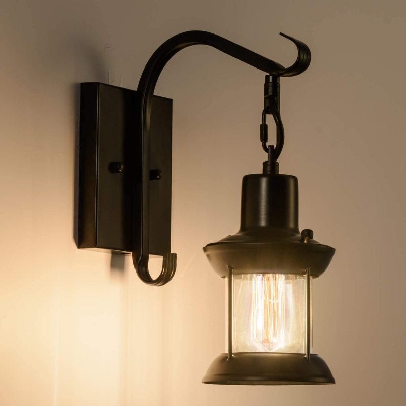 Close-up of the black zupce industrial retro wall light glowing warmly with a vintage filament Edison bulb