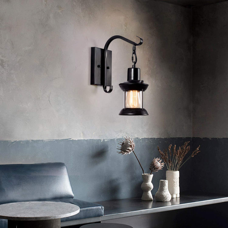 Black zupce vintage industrial lantern wall sconce illuminating a modern, moody living room space
